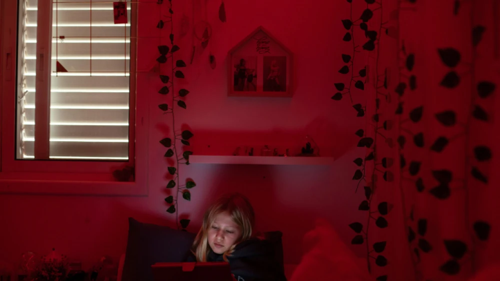 A young girl quarantined in her home in Moshav Haniel, Israel, due to COVID-19, Dec. 23, 2021. Photo by Chen Leopold/Flash90.