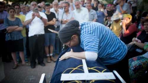 The mother of Hallel Yaffa Ariel and family members mourn over her body during her funeral ceremony in the Jewish settlement of Kiryat Arba in the West Bank on June 30, 2016. Photo by Yonatan Sindel/Flash90.