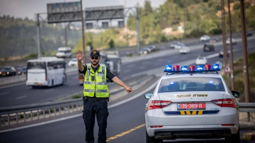 An Israel Police officers stops a car on Route 1 near Ein Hemed, July 10, 2023. Photo by Chaim Goldberg/Flash90.