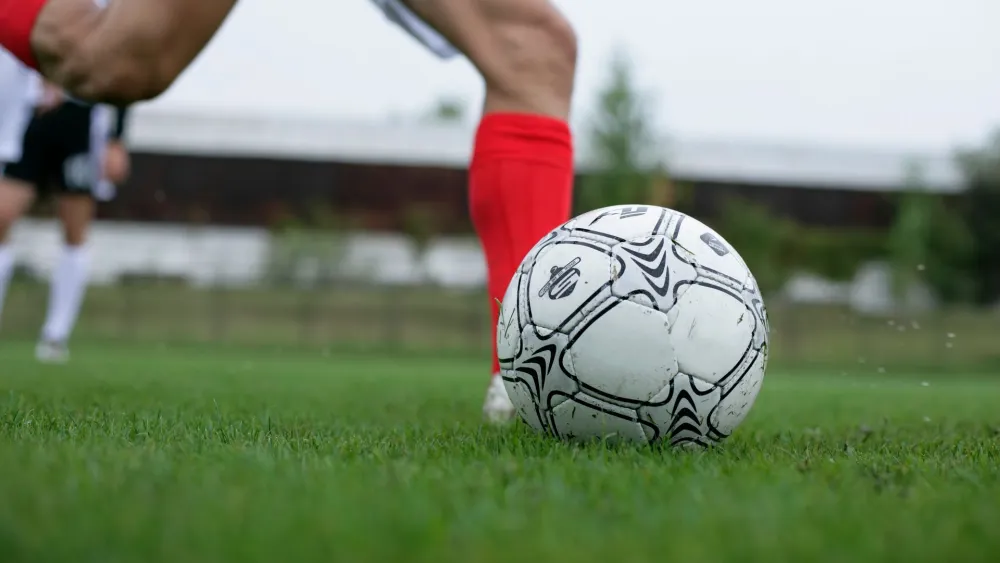People playing soccer on a field. Credit: BOOM Photography/Pexels.
