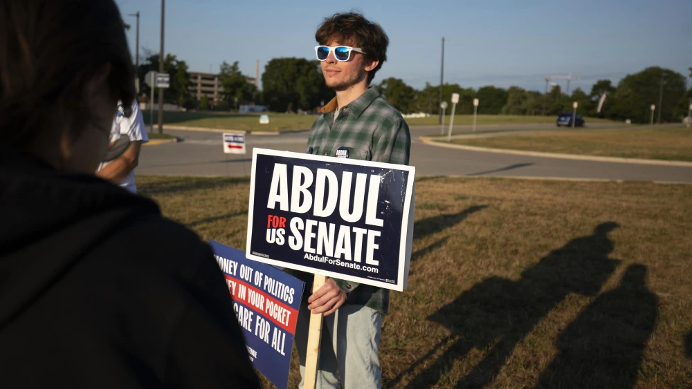 A young supporter of Abdul El-Sayed, a Democratic candidate for Michigan's open U.S. Senate seat, stands outside a polling precinct as voters cast their ballots in the Michigan Primary election in Lansing on Aug. 4, 2026. Photo by Bill Pugliano/Getty Images.