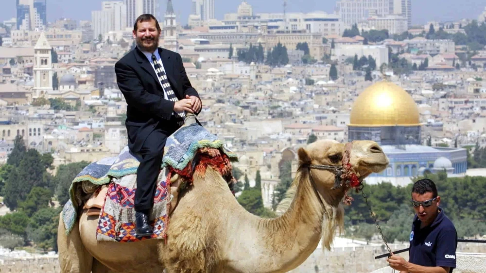 Uri Lupolianski, then the mayor of Jerusalem, riding a camel on the Mount of Olives on July 29, 2003. Credit: Flash90.