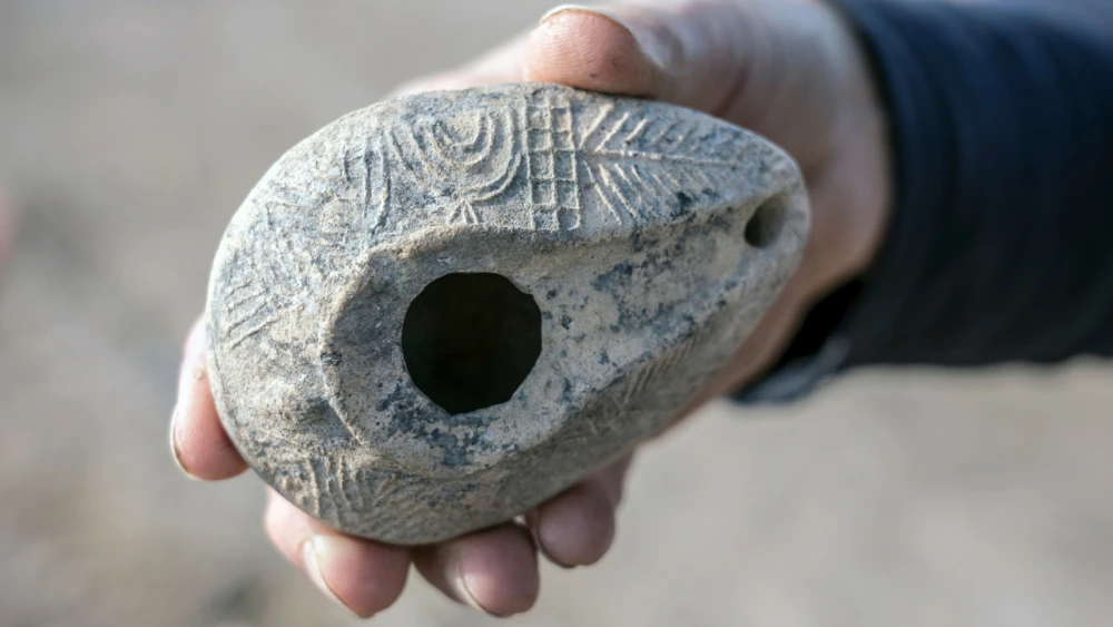 An oil lamp with the seven-branch menorah, found in Usha along the Sanhedrin Trail, on display at the Yigal Allon Center. Photo by Yaniv Berman/Israel Antiquities Authority.