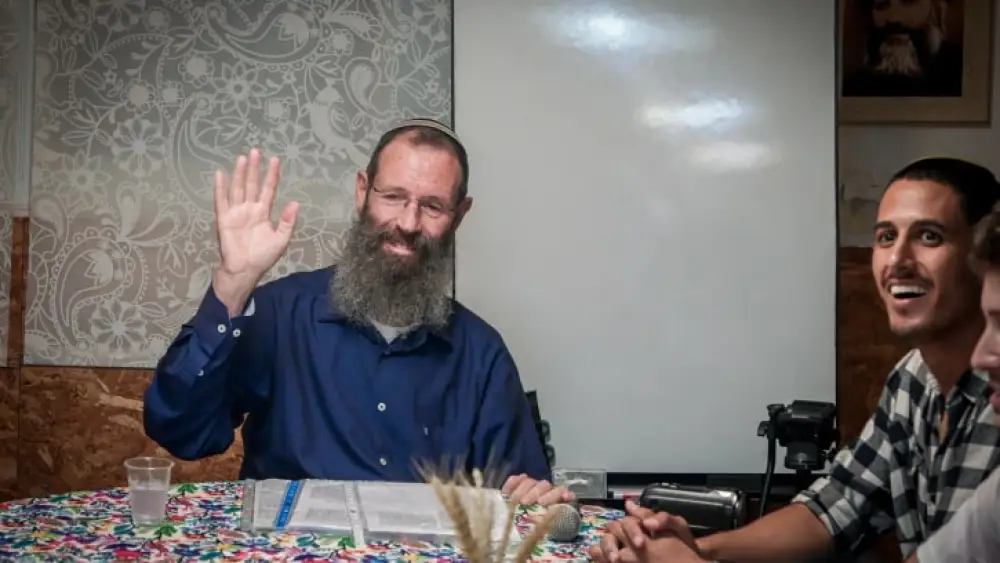 Rabbi Yigal Levinstein delivers a lesson while activists protest against him outside an apartment building in Tel Aviv, Sept. 19, 2023. Photo by Avshalom Sassoni/Flash90.