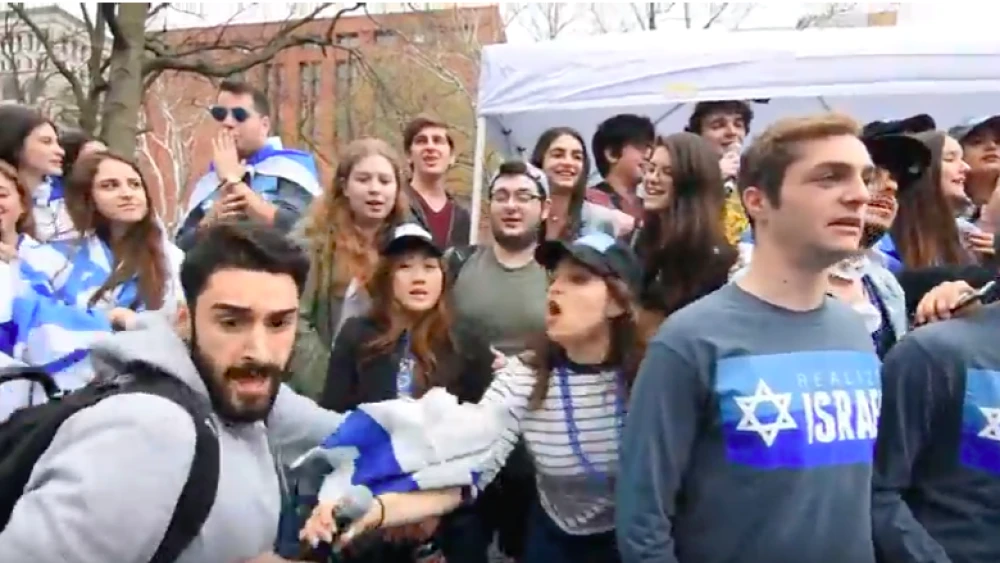 An NYU student stealing an Israeli flag at a pro-Israeli student event called “Rave in the Park” on April 27, 2018. The student was soon arrested. Credit: Screenshot/YouTube.
