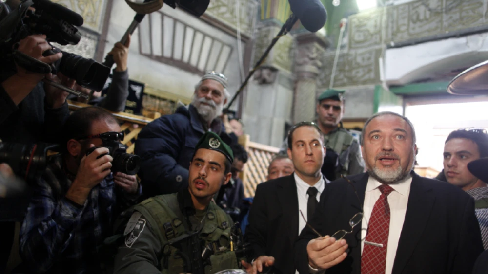 Israeli Defense Minister Avigdor Lieberman is seen surrounded by security as he visits the Tomb of the Patriarchs and Matriarchs in the city of Hebron on Jan. 14, 2013. Photo by Flash90.