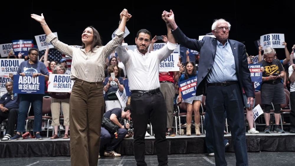 Rep. Alexandria Ocasio-Cortez (D-N.Y.), Michigan Democratic candidate for Senate Abdul El-Sayed and Sen. Bernie Sanders (I-Vt.) greet the crowd after El-Sayed spoke at The People V. The Powerful rally at the Detroit Opera House in Detroit, Michigan on July 18, 2026. Photo by Sarah Rice/Getty Images.