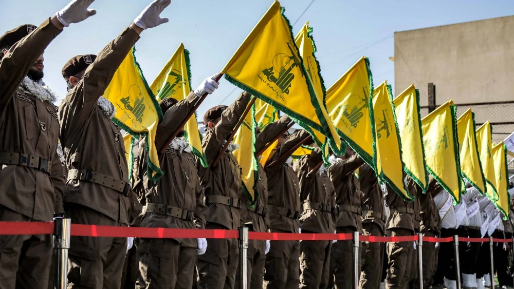 Terroristas de Hezbolá saludan y levantan la bandera amarilla del grupo durante un funeral en Chehabiyeh, en el sur del Líbano, el 17 de abril de 2024. Foto: AFP vía Getty Images.