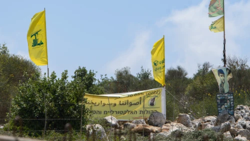 Hezbollah operatives in Lebanon raise the movement's banners at the Israeli border, July 3, 2022. Credit: Ayal Margolin/Flash90.