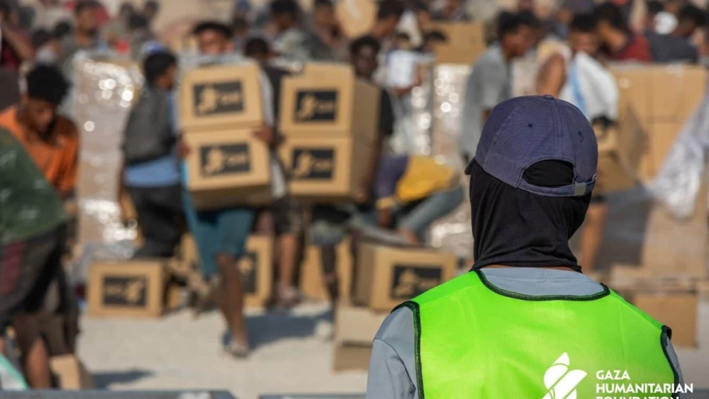 Gazans pick up food packages at a Gaza Humanitarian Foundation aid distribution site. Source: @GHFUpdates/X.