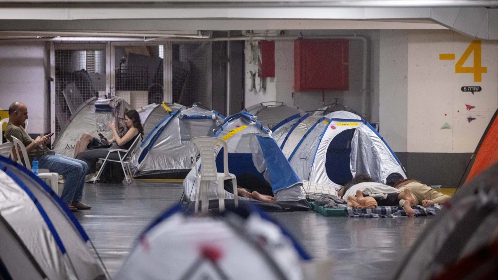 People take shelter in an underground parking lot in Tel Aviv during the war between Israel and Iran, June 24, 2025. Photo by Chaim Goldberg/Flash90.