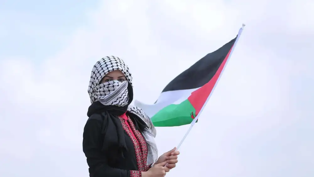 Woman Wearing a Keffiyeh and Holding Palestinian Flag