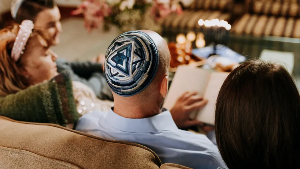 A man wearing a kippah sitting with his family. Credit: RDNE Stock project/Pexels.