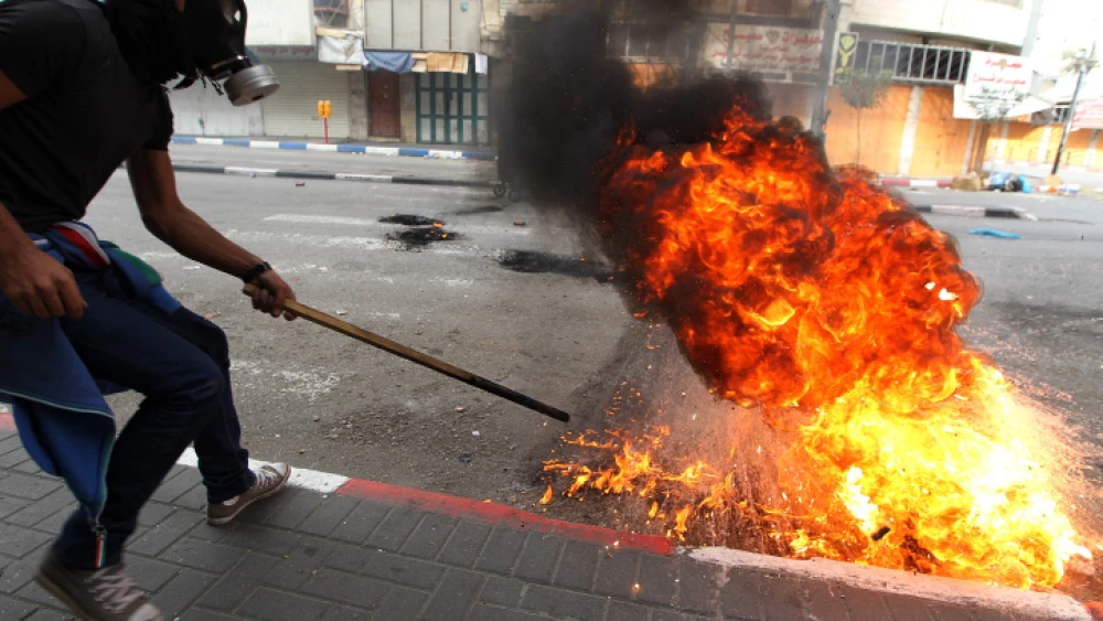 A Palestinian demonstrator uses a slingshot to hurl stones at Israeli troops during clashes as Palestinians call for a “Day of Rage” in response to U.S. President Donald Trump's recognition of Jerusalem as Israel's capital, in the West Bank city of Hebron, Dec. 22, 2017. Photo by Wisam Hashlamoun/Flash90.