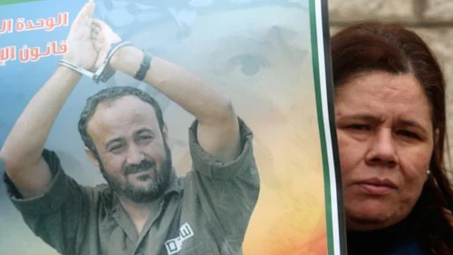A Palestinian woman holds a portrait of Palestinian terrorist prisoner Marwan Barghouti during a rally in Ramallah, the headquarters of the Palestinian Authority, on March 27, 2012. Credit: Issam Rimawi/Flash90.