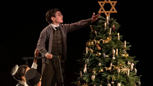 A scene from the play "Leopoldstadt," which opens in 1899 at a family Christmas party, where one of the children places a large Star of David atop the tree. Credit: "Leopoldstadt."