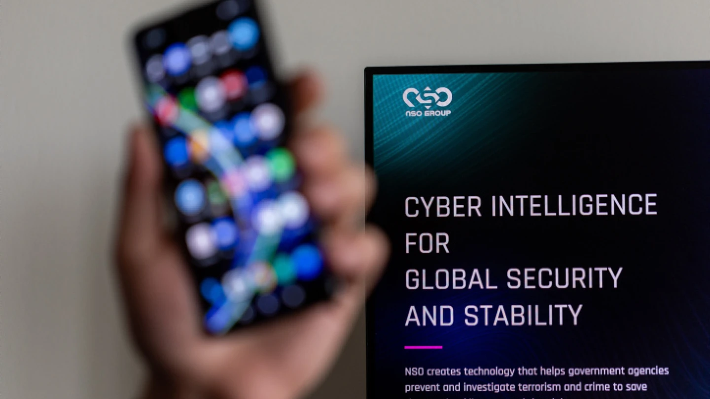 An Illustration of a man holding his phone with NSO GROUP logo on a computer screen at the background, in Jerusalem, on February 7, 2022. Photo by Yonatan Sindel/Flash90.