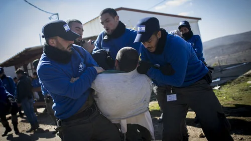 Israeli police forces carry out the evacuation of Amona as a resident resists the court-ordered process Feb. 2. Credit: Yonatan Sindel/Flash90.
