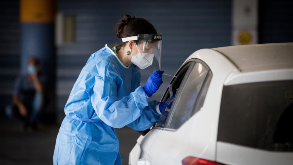 Shaare Zedek medical worker wearing protective clothing takes a swab from a woman to test for the coronavirus disease (COVID-19), outside the coronavirus unit at Shaare Zedek Hospital in Jerusalem on Sept. 10, 2020. Photo by Yonatan Sindel/Flash90.