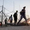 Palestinians cross into Israel through a hole in the security fence in Judea, July 25, 2021. Photo by Wisam Hashlamoun/Flash90.