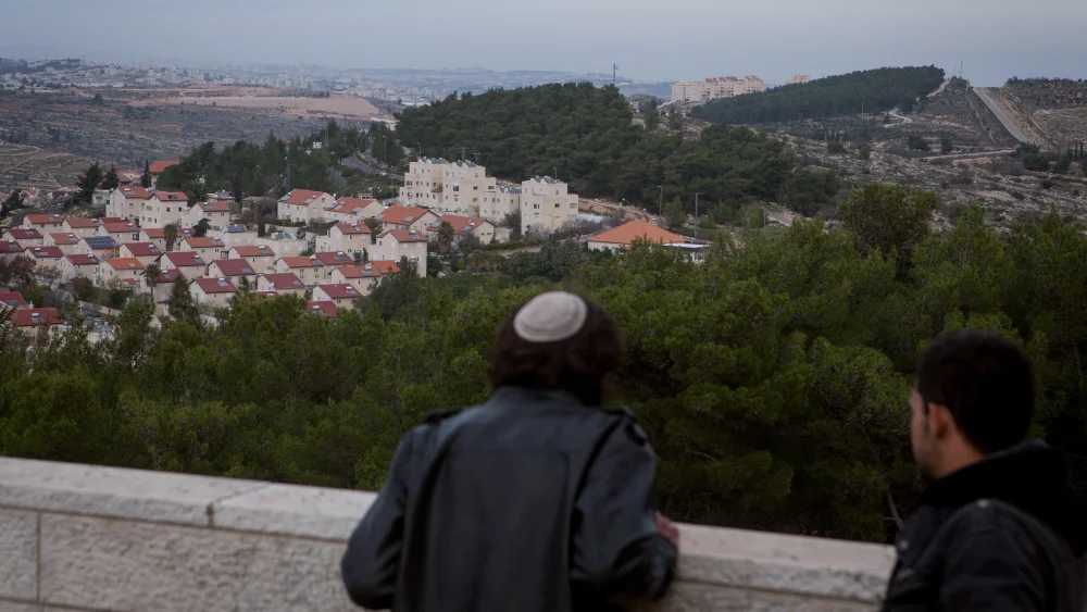A Jewish man and a Palestinian man take in views of the Jewish town of Efrat (foreground) and the Palestinian city of Bethlehem (background) on Dec. 17, 2014. Credit: Miriam Alster/Flash90.