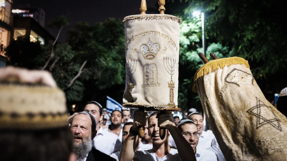 Carrying Torah scrolls as they dance during the celebration of Simchat Torah, marking the end of the annual cycle of the reading of the Torah and starting again, at Rabin Square in Tel Aviv, on Oct. 1, 2018. Photo by Tomer Neuberg/Flash90.
