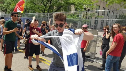 A counter-protester tears an Israeli flag on Third Street in Dayton next to Courthouse Square, the site of the Ku Klux Klan-affiliated Honorable Sacred Knights of Indiana's rally, May 25, 2019. Photo by Corine Fairbanks.