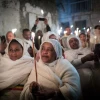 Ethiopian Orthodox Christian worshippers hold candles outside Deir Al-Sultan in the Church of the Holy Sepulcher during the ceremony of the Holy Fire in Jerusalem's Old City, Saturday, April 27, 2019. Photo by Noam Revkin Fenton/Flash90.