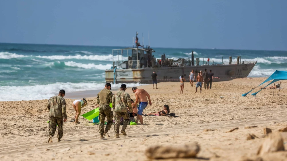 U.S. military personnel and Israelis near a U.S. Army vessel that washed up on the beach in the southern Israeli city of Ashdod, May 25, 2024. Photo by Liron Moldovan/Flash90.