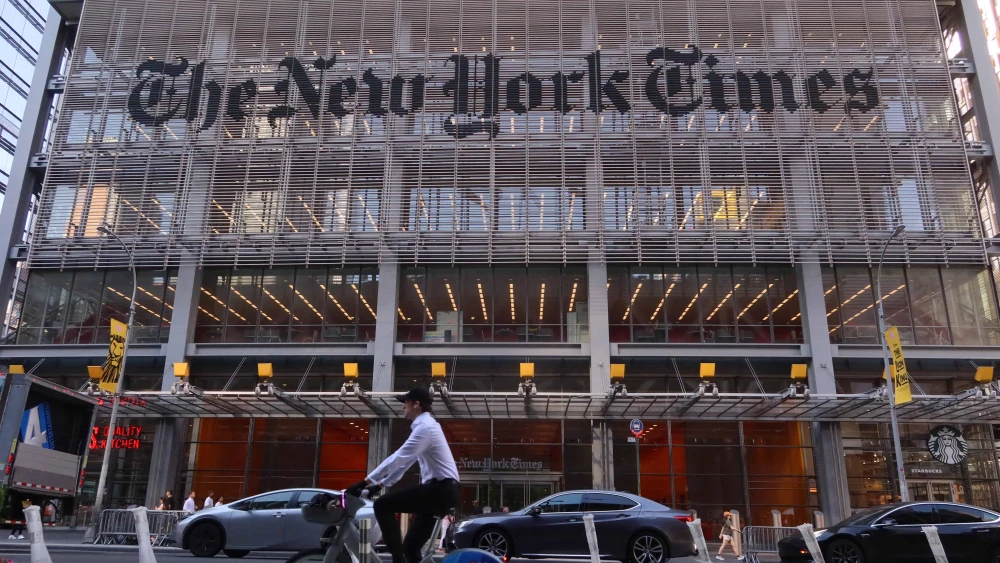 A person cycles past the front of “The New York Times” headquarters on Eighth Avenue in Midtown Manhattan on June 24, 2025. Photo by Gary Hershorn/Getty Images.