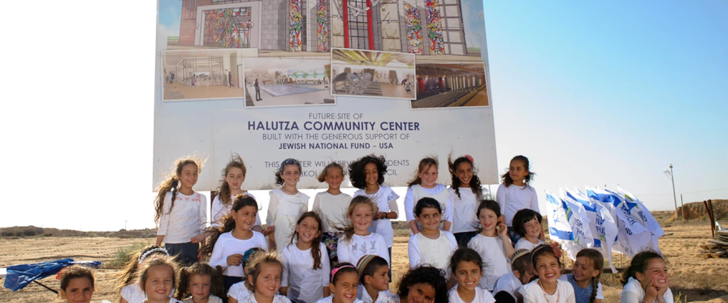 Children of Halutza sit in front of the site of the new state-of-the-art Halutza Community Center. Credit: Jewish National Fund-USA.