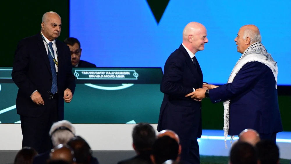 FIFA President Gianni Infantino, center, speaks with Palestinian Football Association President Jibril Rajoub as Israel Football Association Vice President Basim Sheikh Suliman, left, looks on during the FIFA Congress in Vancouver, Canada, April 30, 2026. Photo by Don MacKinnon/AFP via Getty Images.