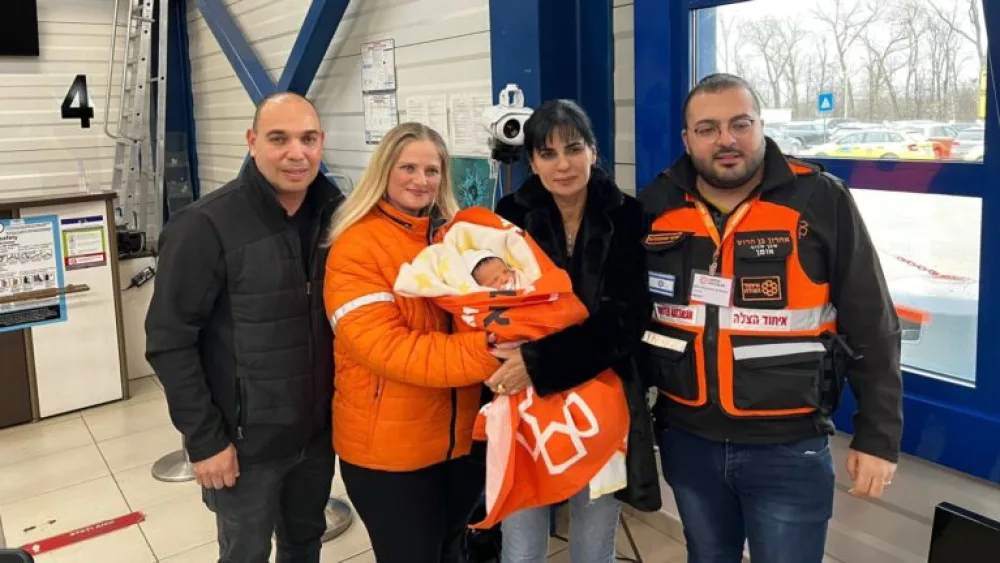 Aharon Ben Harush, United Hatzalah’s deputy commander of the relief mission to the Ukrainian-Moldovan border, left, helped these Israeli parents unite with their daughter born to a Ukrainian surrogate. Photo courtesy of United Hatzalah