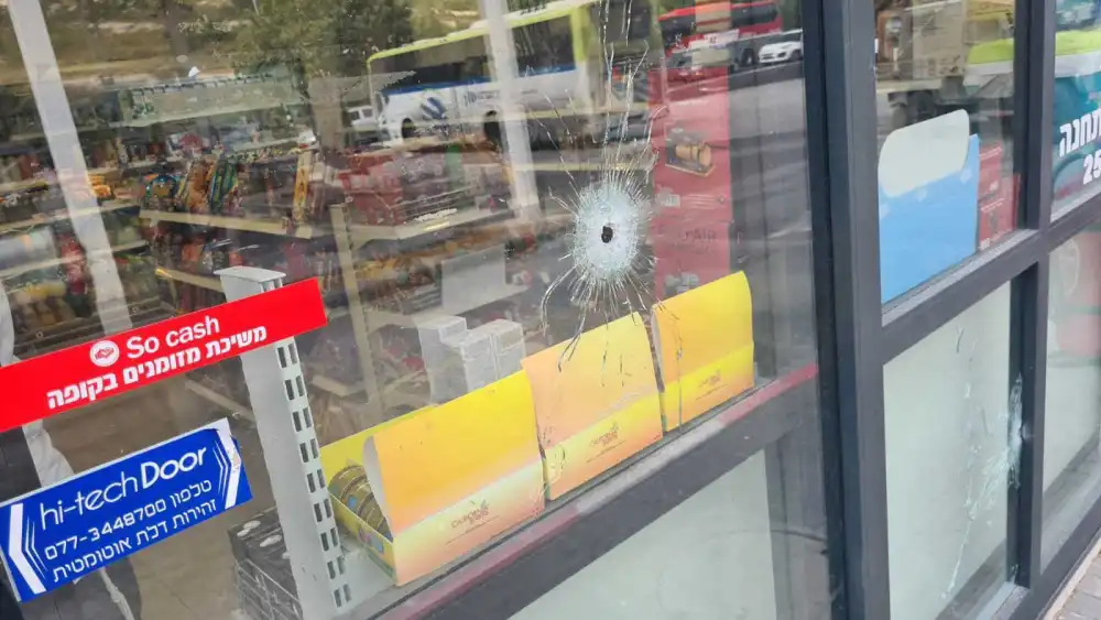 A bullet hole in the glass door of a convenience store in Eli in Samaria. Source: Screenshot.
