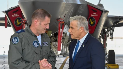 Israeli Air Force chief Brig. Gen. Tomer Bar speaks with Israeli Prime Minister Yair Lapid at an air base in southern Israel, with an F-35 "Adir" fighter jet in the background. Credit: Kobi Gideon/GPO.