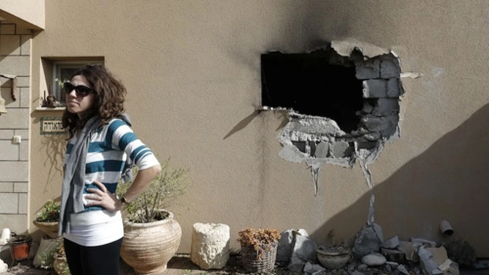 An Israeli woman stands outside a damaged house hit by a rocked fired from the Gaza Strip that hit a house near the Israel-Gaza border, Friday, Nov. 16, 2012. Credit: Tsafrir Abayov/Flash90.