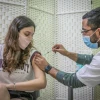 A young woman gets vaccinated at Clalit COVID-19 vaccination center in Rehovot on Jan. 4, 2021. Photo by Yossi Aloni/Flash90.