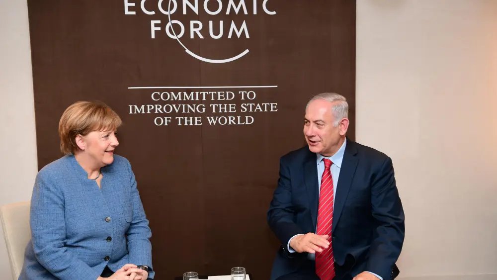 Israeli Prime Minister Benjamin Netanyahu and German Chancellor Angela Merkel meet at the World Economic Forum in Davos. Credit: Amos Ben-Gershom/GPO.