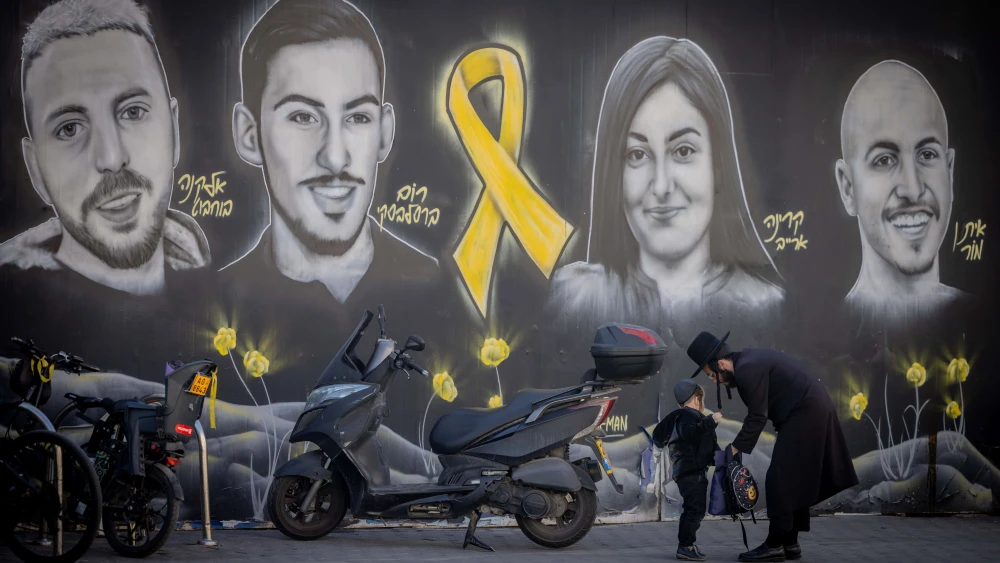 People walking next to pictures of Israelis held hostage by Hamas terrorists in Gaza, in Jerusalem, Jan. 13, 2025. Photo by Chaim Goldberg/Flash90.