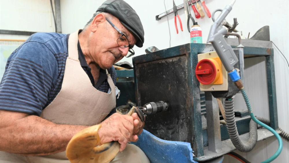 Shofar specialist Shimon Keinan at work at the Kol Shofar workshop in Givat Yoav in the southern Golan Heights, August 23, 2021. Photo by Michael Giladi/Flash90.