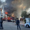 Israeli firefighters work to extinguish flames at a factory in Sderot ignited by a rocket launched by the Palestinian Islamic Jihad terror group over the Gaza border into Israel on Nov. 12, 2019. Photo by Flash90.