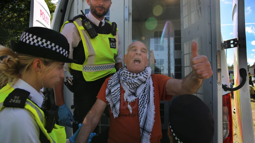 A protester is arrested after holding a sign saying saying "Saving Lives is not Terrorism I support Palestine Action," during the demonstration at Woolwich Crown Court on June 12, 2026 in London, England. Photo by Martin Pope/Getty Images.