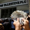 An employee of the Palestinian Authority displaying money he withdrew from a bank in Gaza City on June 11, 2014. Photo by Abed Rahim Khatib/Flash90.