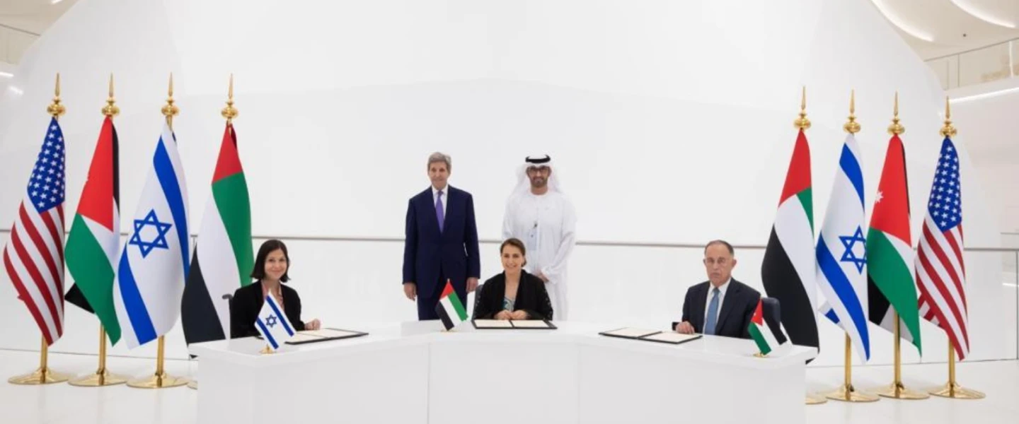 Israeli Energy and Water Resources Minister Karine Elharrar, UAE Climate Change Minister Mariam Almheiri and Jordan Water and Irrigation Minister Mohammed Al-Najjar sign a water agreement at the Dubai Expo on Nov. 22, 2021, as U.S. Climate Envoy John Kerry and UAE Crown Prince Mohammed bin Zayed look on. Credit: Israeli Foreign Ministry.