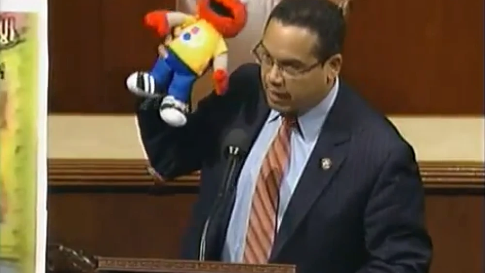 Click photo to download. Caption: Holding Elmo, Congressman Keith Ellison makes the case against defunding Palestinian Sesame Street. Credit: YouTube.