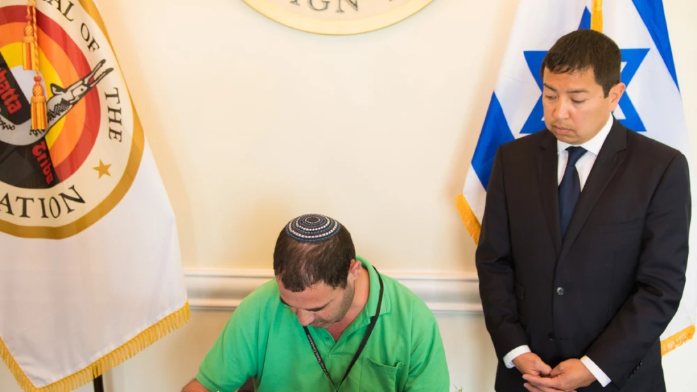 As David Sickey looks on, Consul General of Israel to the Southwest U.S. Gilad Katz signs a guest book during a visit to the Coushatta Tribe of Louisiana in May 2018. Credit: Courtesy David Sickey.