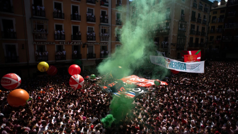 Revellers gather to celebrate during the "Chupinazo" (rocket launch) marking the official start of the San Fermin Festival in Plaza Consistorial outside the Town Hall of Pamplona in northern Spain on July 6, 2026. Photo by Jorge Guerrero / AFP via Getty Images.