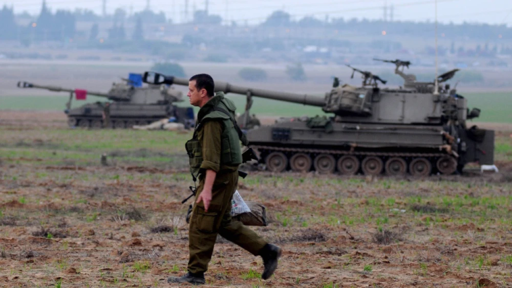An Israeli soldier walks next to a mobile artillery unit positioned outside the northern Gaza Strip on Nov. 21, 2012. Photo by Yossi Zeliger/Flash90.