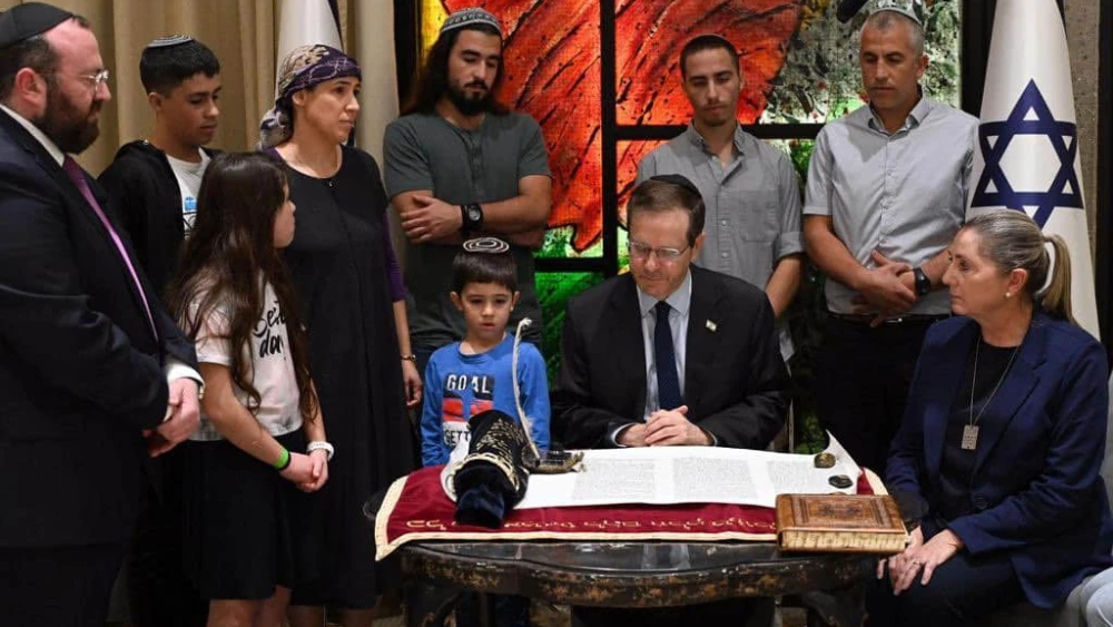 President Isaac Herzog writes a letter in a Torah scroll in honor of the victims of Kibbutz Be'eri, Dec. 3, 2023. Photo by Haim Zach/GPO.
