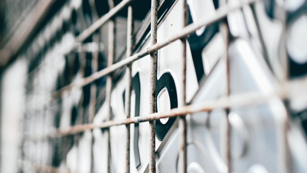License plates behind a wire fence in a recycling yard. Credit: Mariya Muschard/Pixabay.